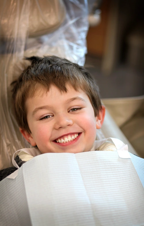 A boy with a big smile while visiting the dentist.