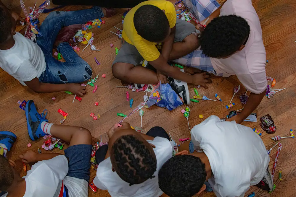 Kids sitting on floor in classroom surrounded by candy.