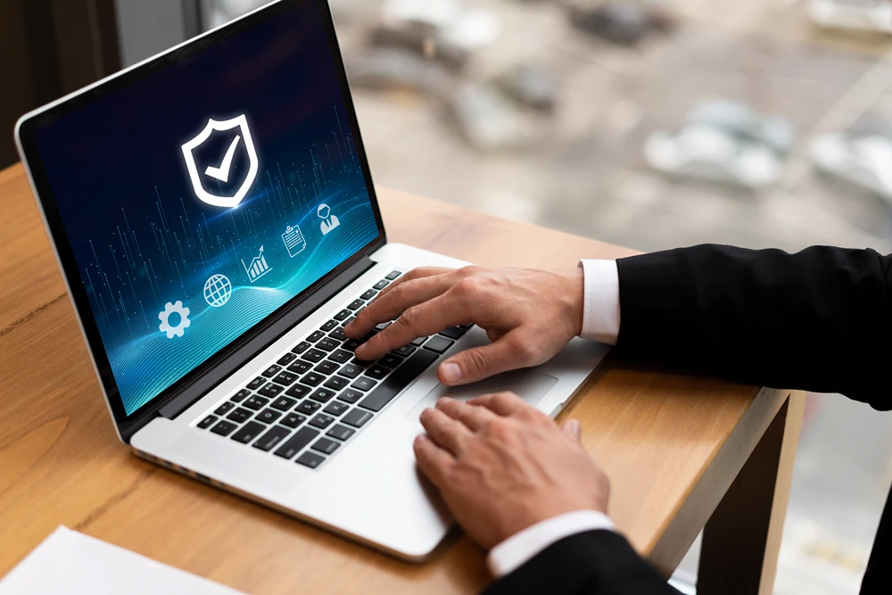 Overview of hands of a man a suit accessing a laptop.