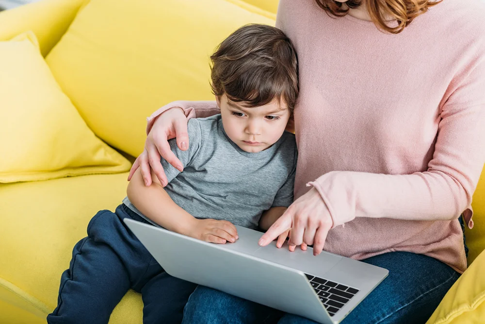 Mother showing her son something on a laptop.